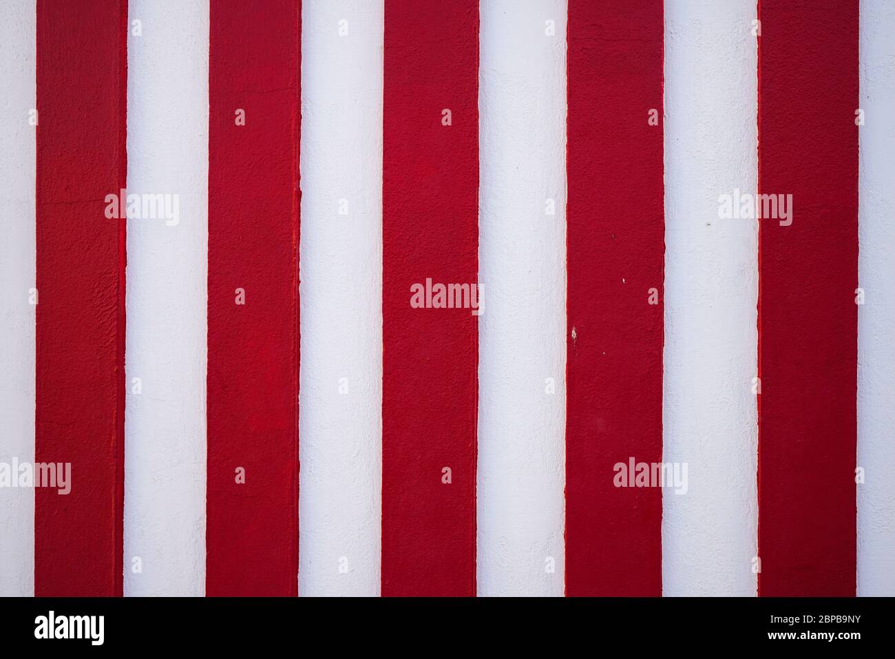 Red and white vertical stripes background pattern. An abstract colorful striped texture or backdrop with copy space. Stock Photo