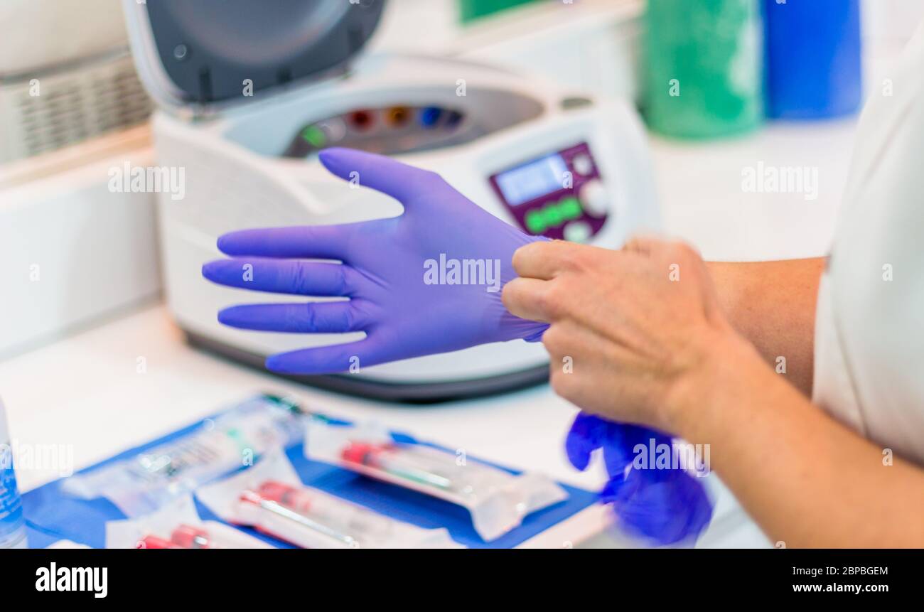 Doctor putting on a glove Stock Photo