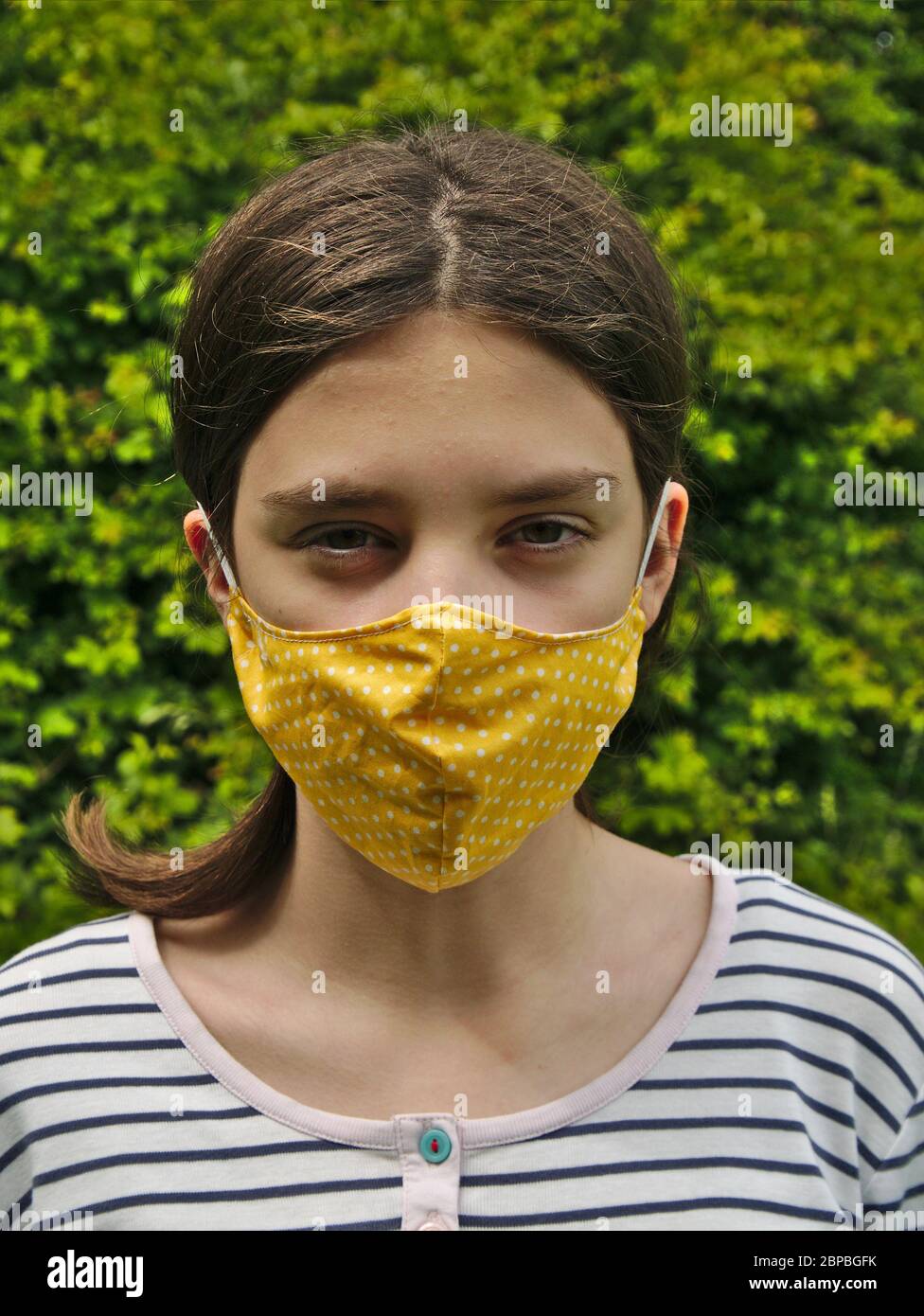 Young teenage girl wearing face mask covering Stock Photo
