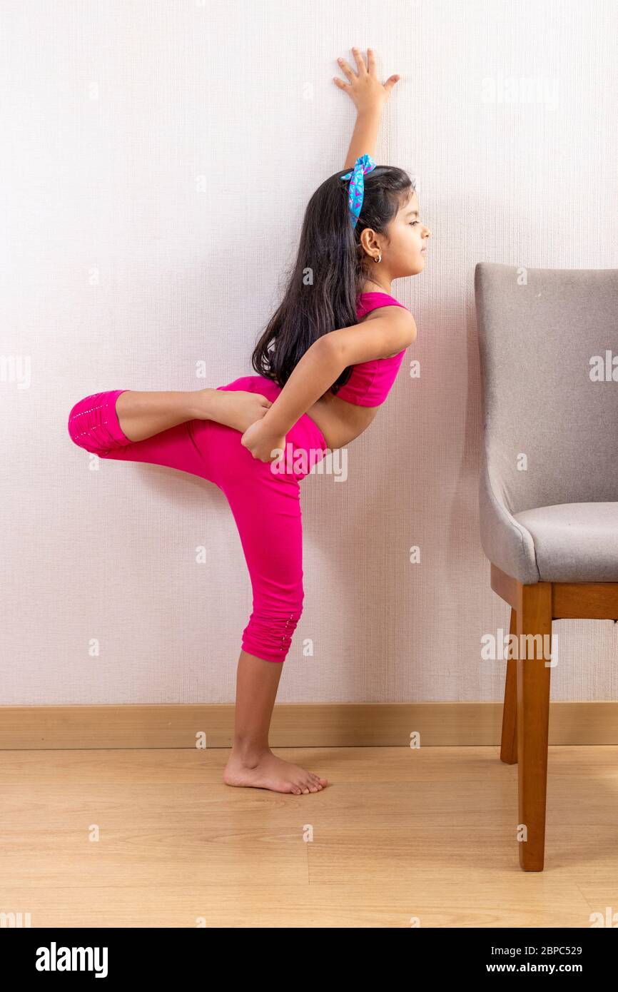 Cute little girl doing yoga at home Stock Photo - Alamy