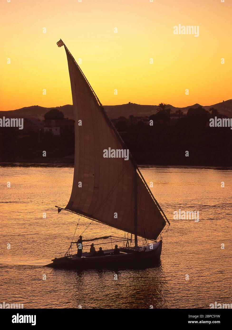 Felucca sailing on River Nile at sunset, Aswan, Aswan Governorate, Republic of Egypt Stock Photo