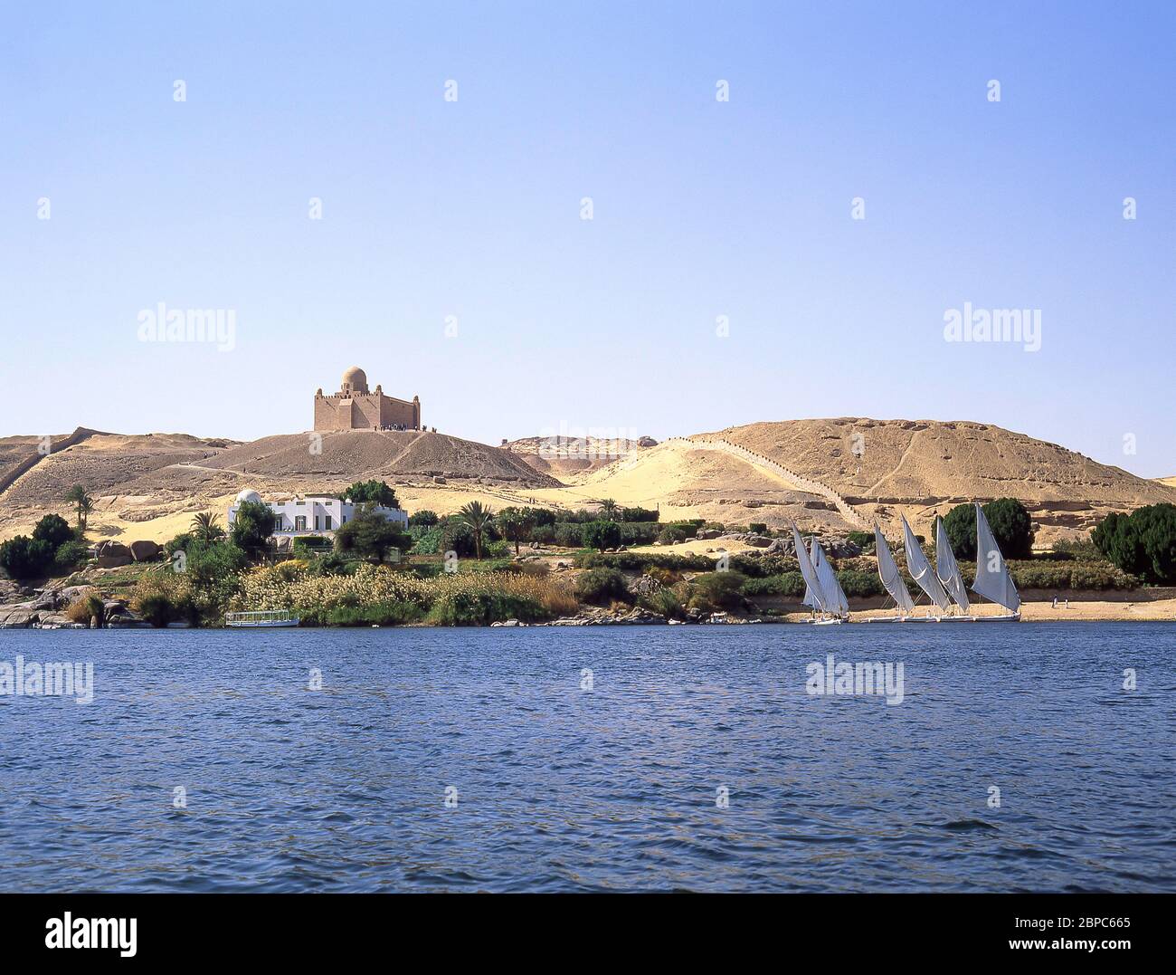 Feluccas and Mausoleum of Aga Khan on bank of River Nile at Aswan, Aswan Governorate, Republic of Egypt Stock Photo