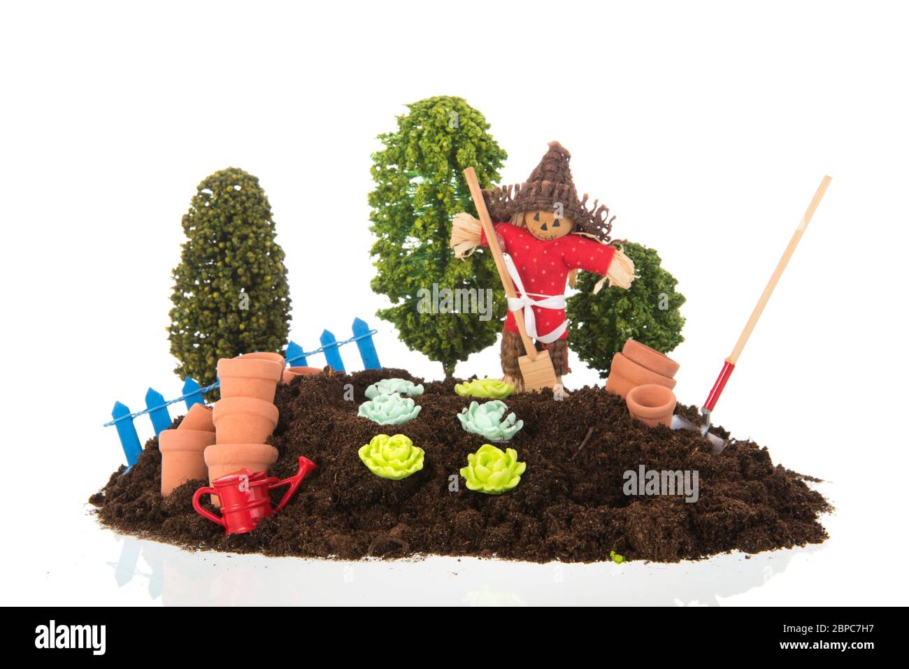 Vegetable garden with scare crow isolated on white background Stock Photo