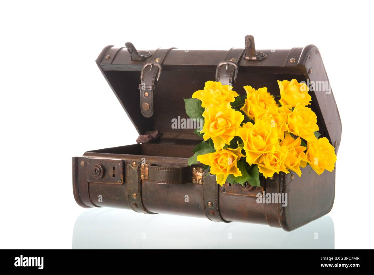 Vintage suitcase with yellow roses isolated over white background Stock Photo