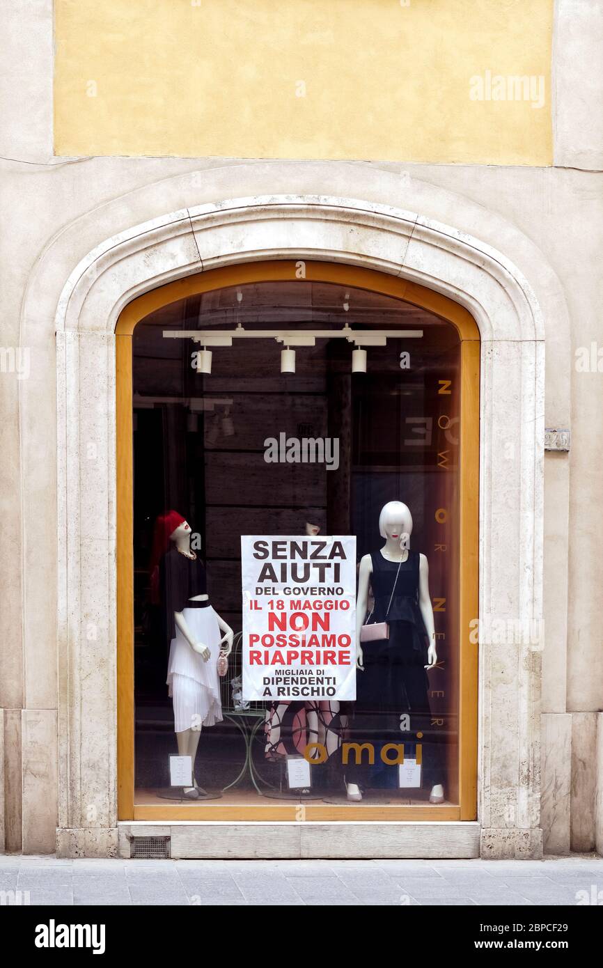 Italian retailers ask the Italian Government for help to reopen their closed businesses due to the lockdown for the Corona Virus. Message on shops windows and front doors on billboard sign with written: Senza aiuti del Governo il 18 Maggio non possiamo riaprire. Migliaia di dipendenti a rischio. (Without Government aid, on 18 May we cannot reopen. Thousands of employees at risk). Covid 19 Phase 2 starts on Monday 18 May 2020. According to the latest decree of the Italian Government, bars and restaurants, shops, personal care services, public offices and museums will reopen. Rome, Italy Europe. Stock Photo