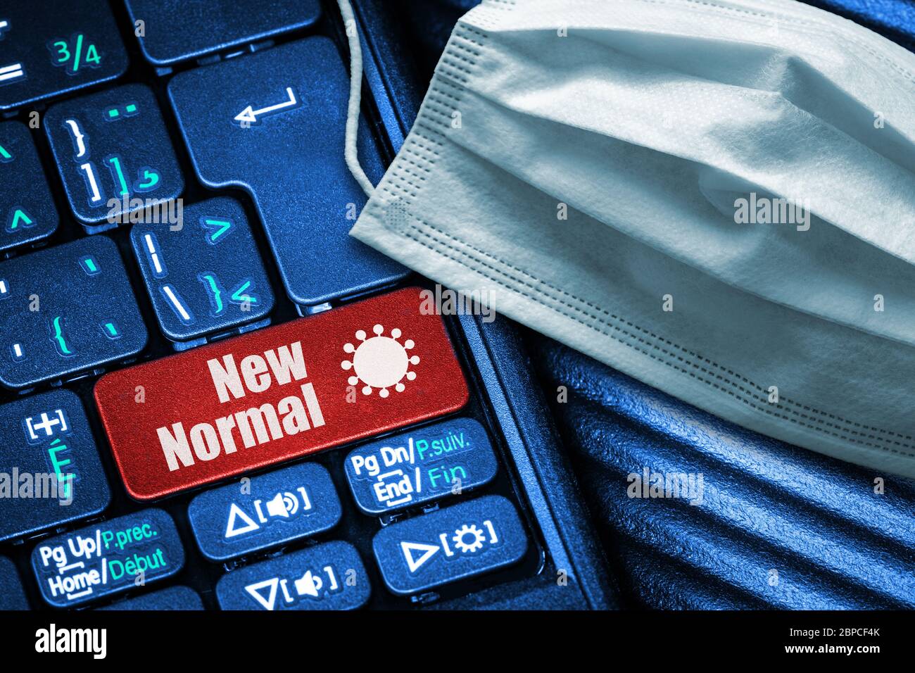Concept of New Normal following Covid-19 reopening of economy and returning to work as illustrated by computer keyboard with red button text and face Stock Photo