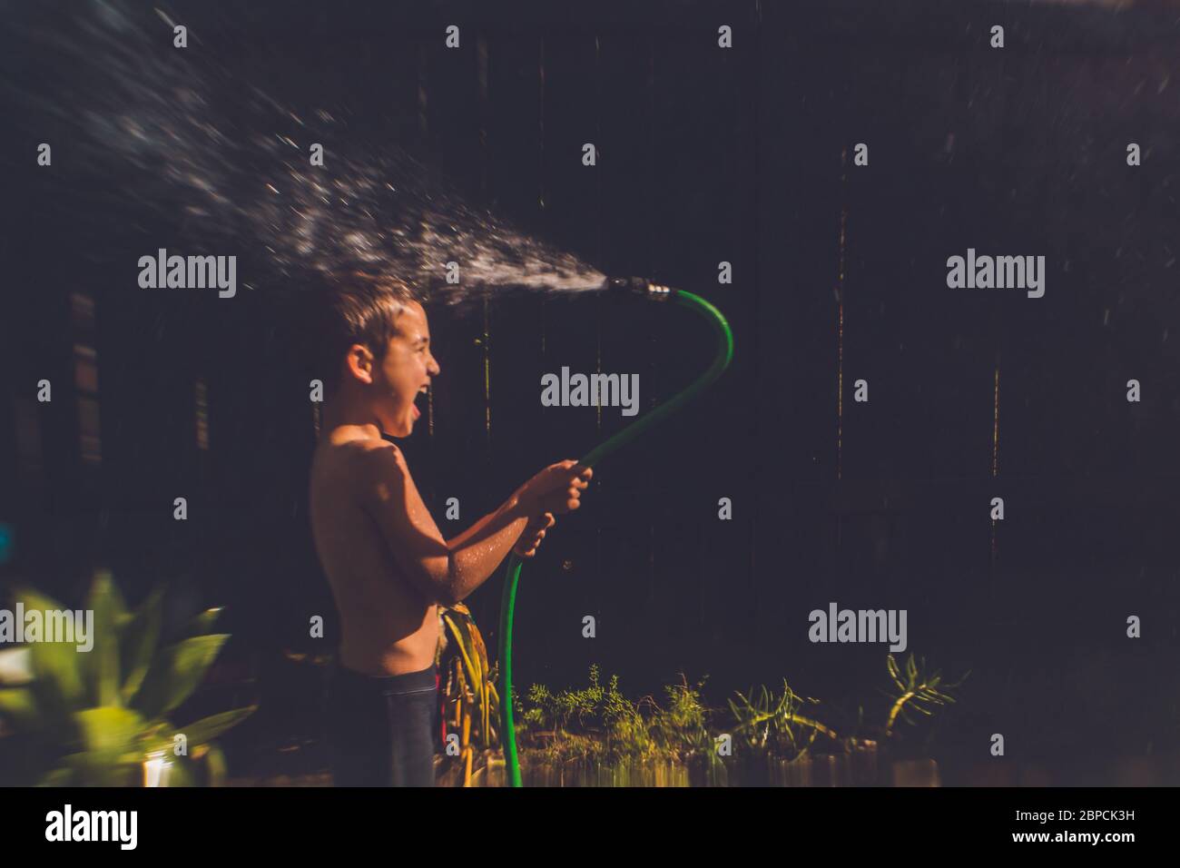 Backyard water fun with a hose stock photo alamy