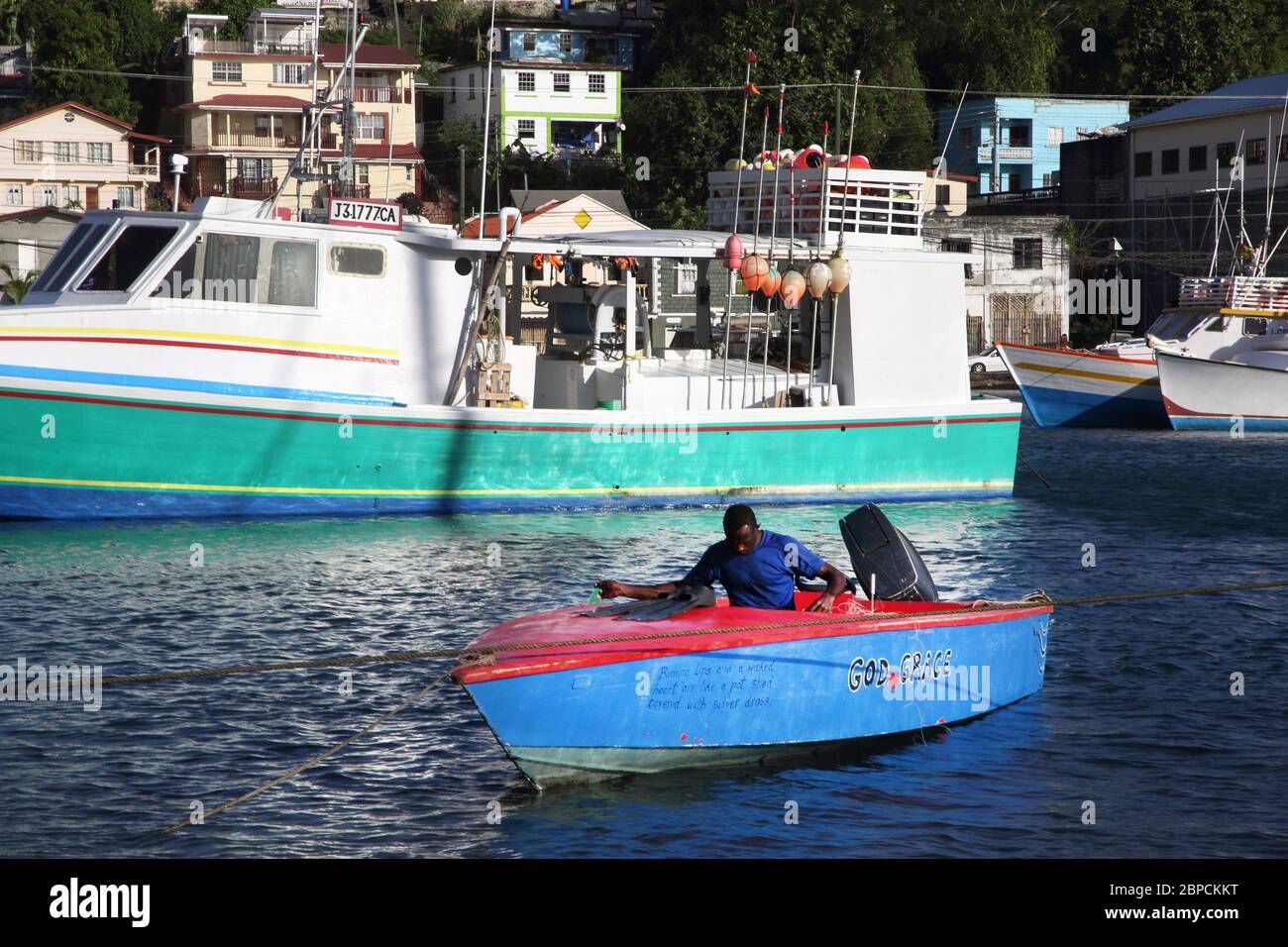 St George's Grenada Carenage Harbour Man in Small Boat with Fishing Line Stock Photo