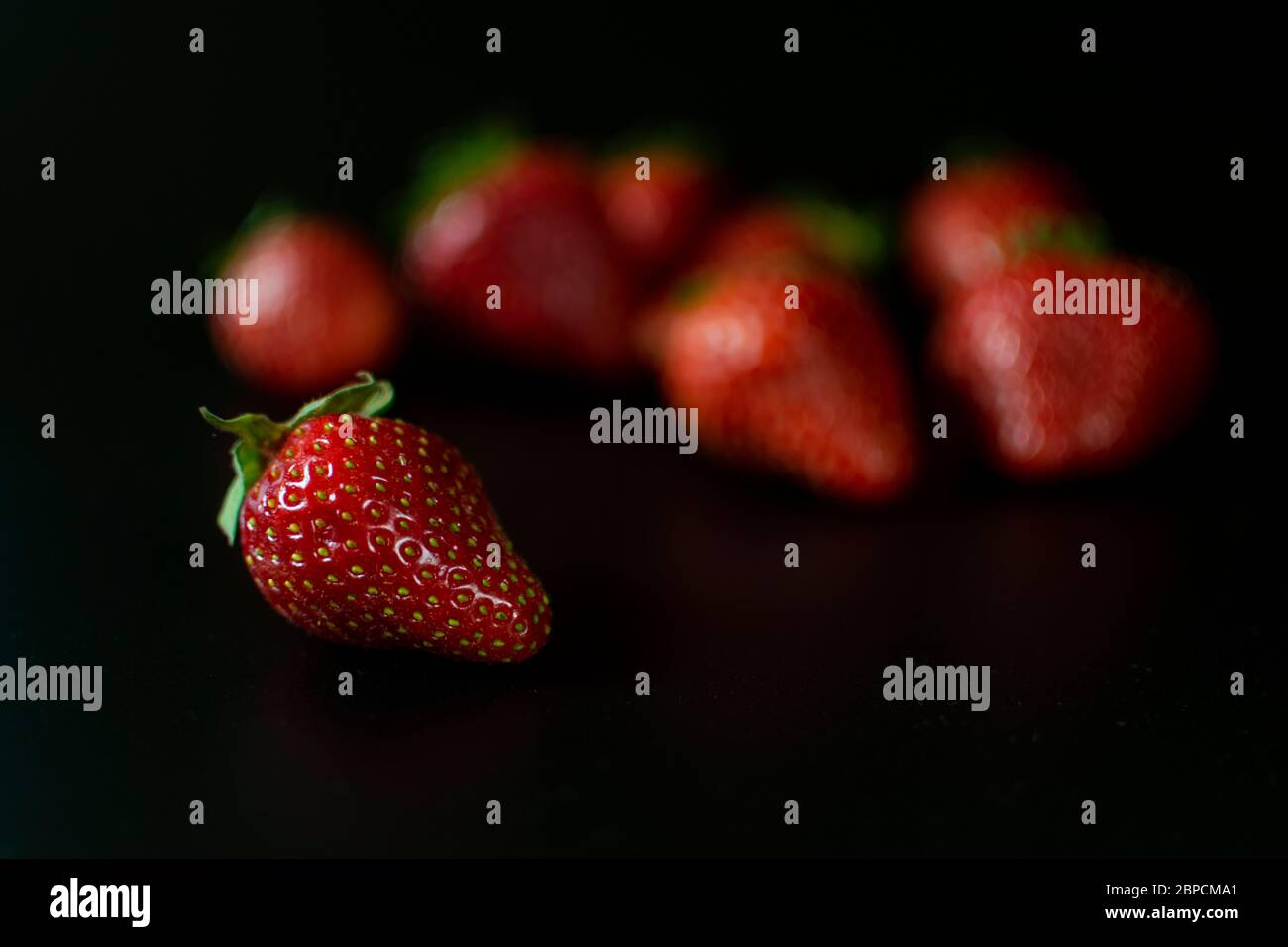 Fresh and juicy red strawberries on black background . Selective focus ...