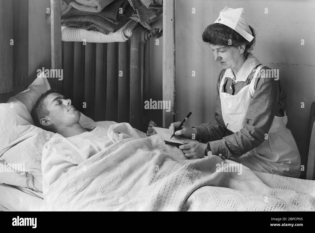 Nurse writing a Letter Home for a wounded American Soldier at the American Military Hospital No. 1, Neuilly, France, Lewis Wickes Hine, American National Red Cross Photograph Collection, June 1918 Stock Photo