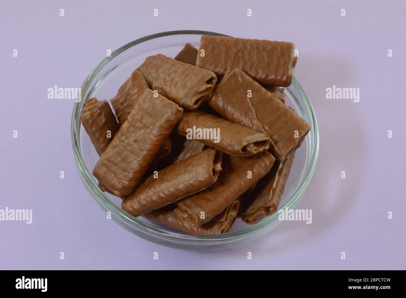 Chocolate covered wafer crepe cookies in glass bowl on lavender