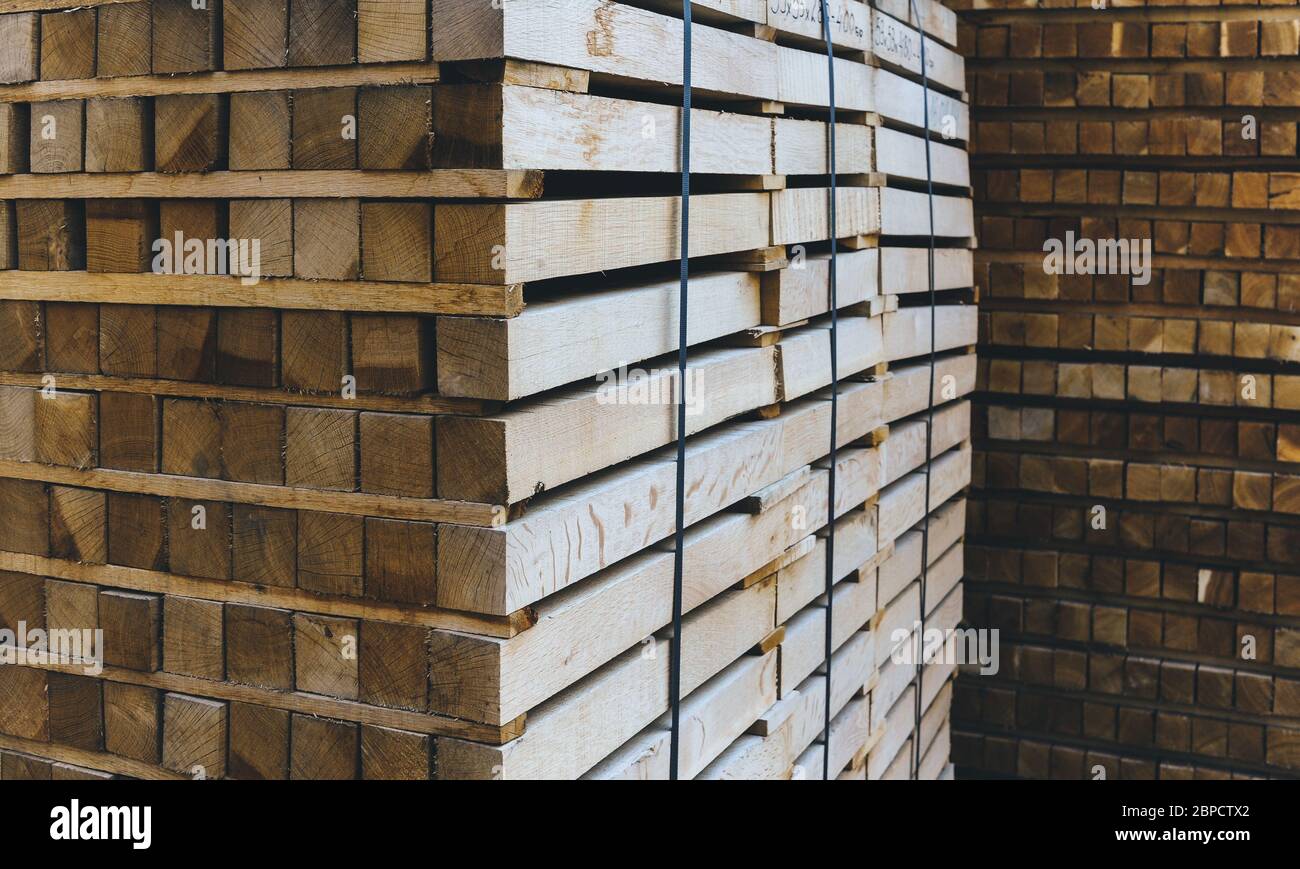 Stack of wooden bars. Square ends of the wooden bars. Wood timber construction material for background and texture. close up. Stock Photo