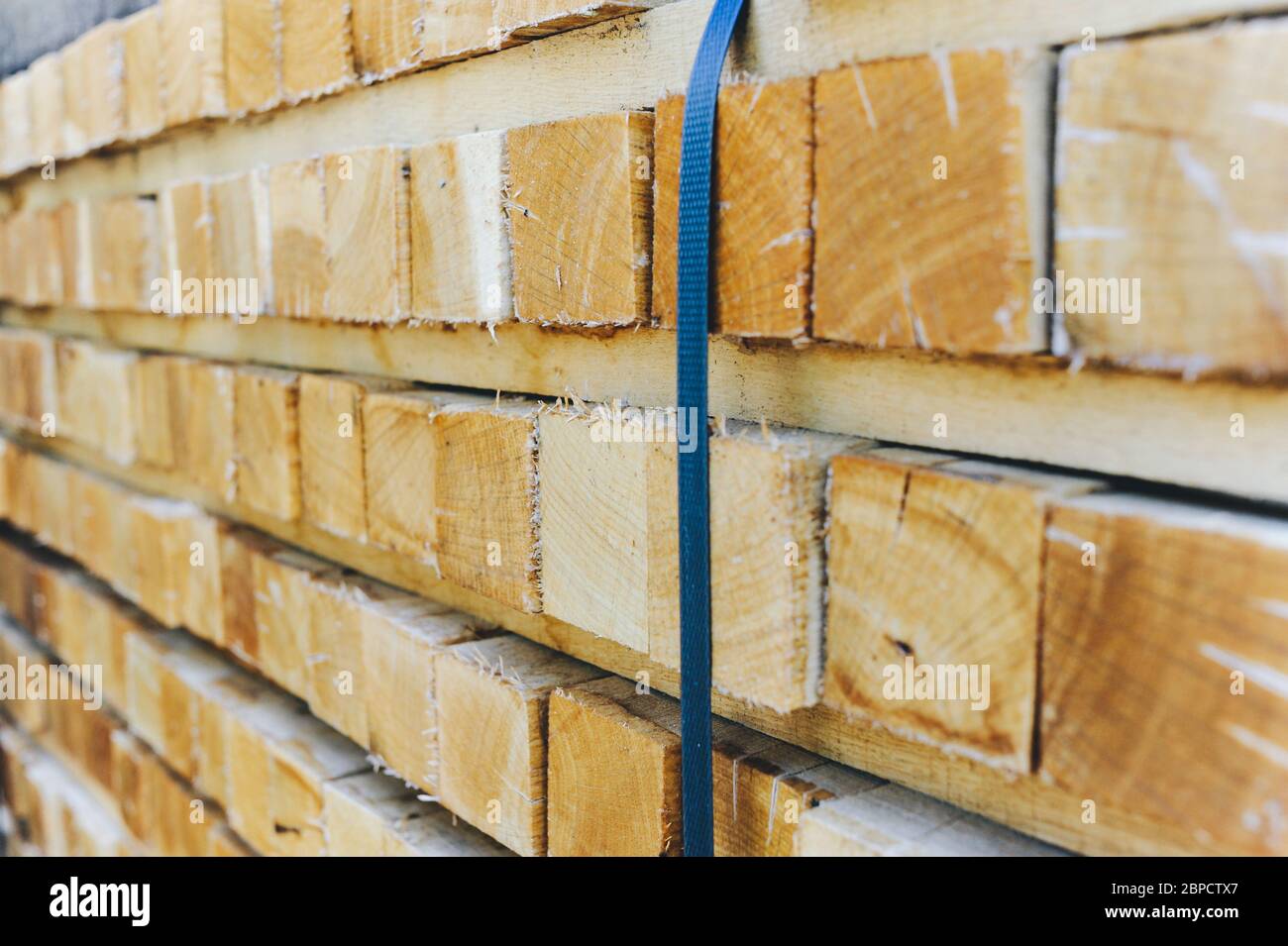 Stack of wooden bars. Square ends of the wooden bars. Wood timber construction material for background and texture. close up. Stock Photo