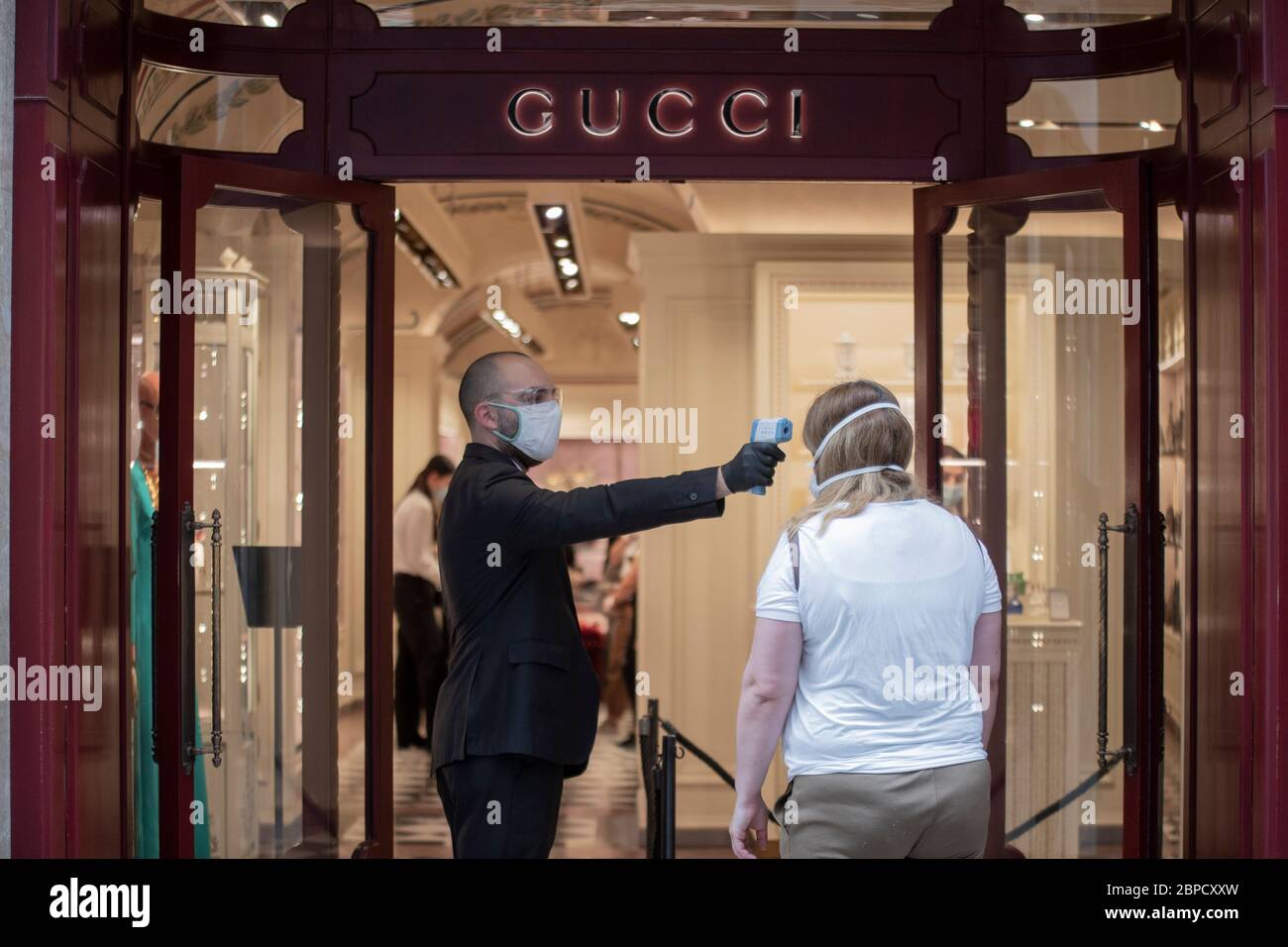 Rome, Italy. 18th May, 2020. Coronavirus: an employee of the store in uses the thermoscanner to measure fever during the reopening of the commercial activities in Rome, Italy.