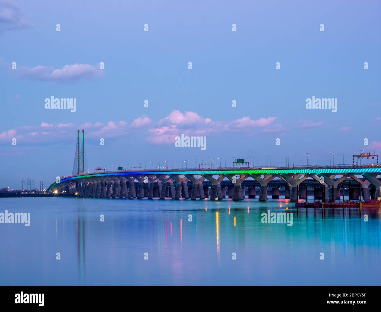The Samuel De Champlain Bridge linking Montreal with the south shore is illuminated in rainbow colors on the Saint Lawrence River. Stock Photo