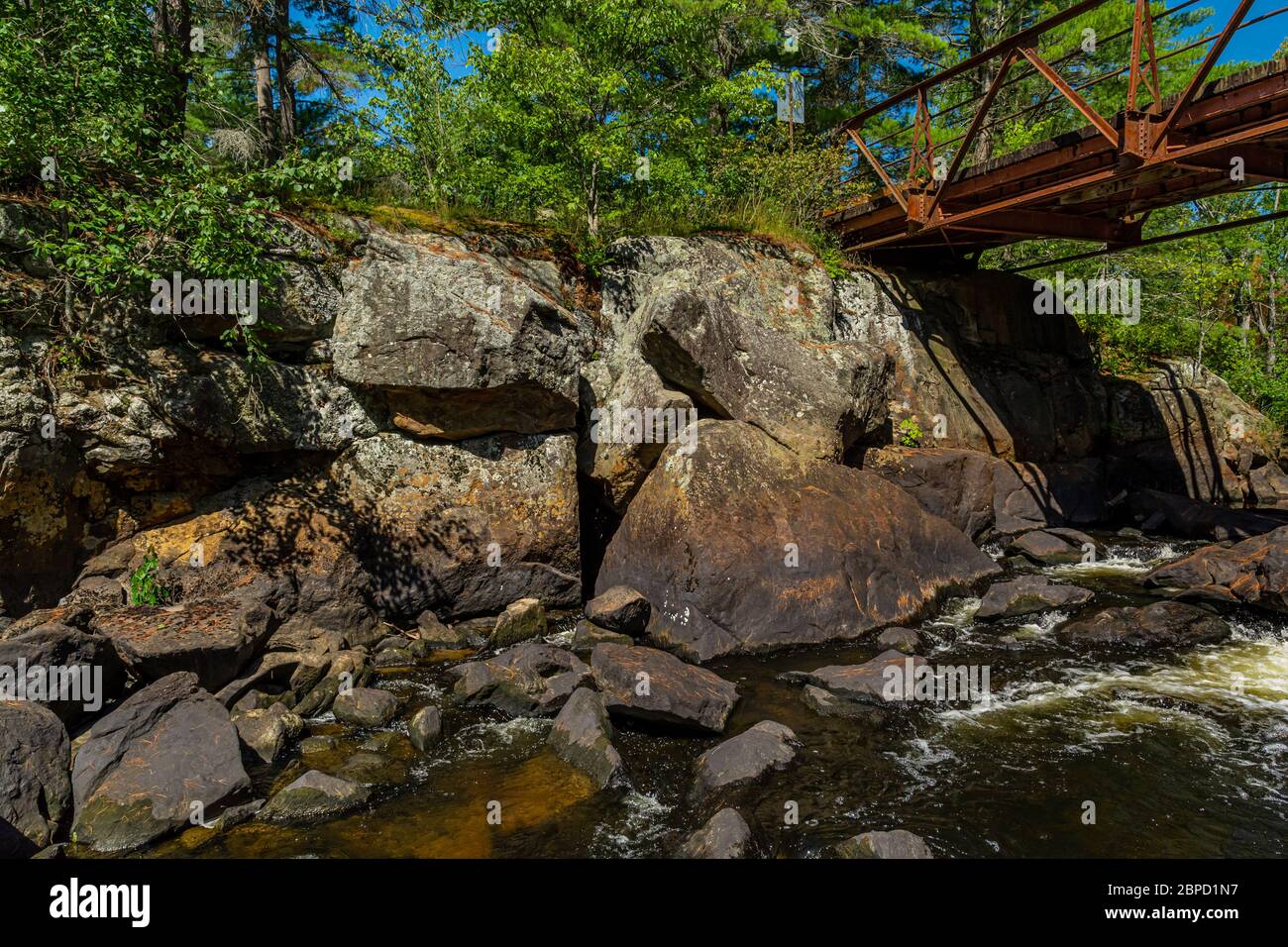 Victoria Falls Conservation Area  showing main bridge, two tone textured rocks and green forest on a sunny summer gorgeous day Stock Photo