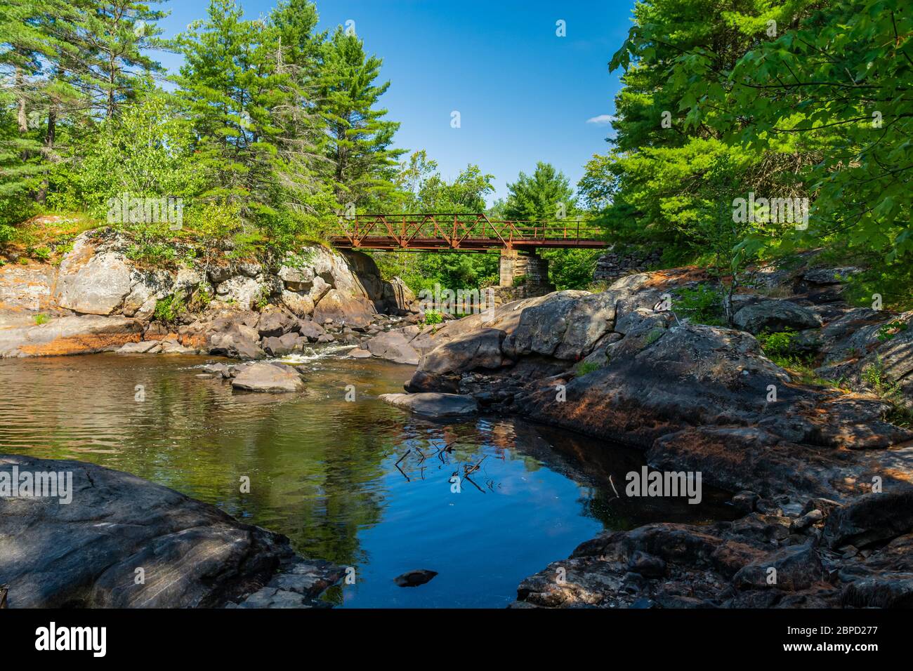 Victoria Falls Conservation Area  showing main bridge, two tone textured rocks and green forest on a sunny summer gorgeous day Stock Photo