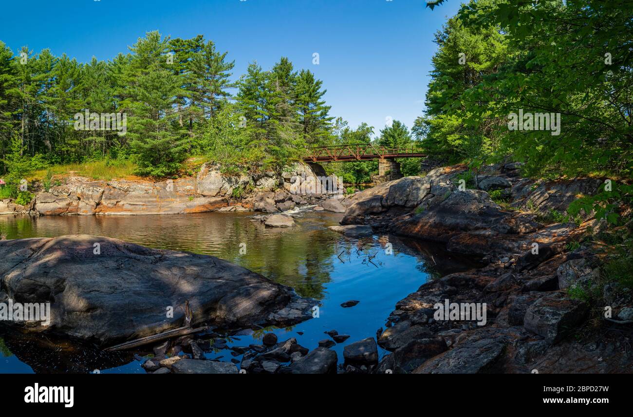 Victoria Falls Conservation Area showing main bridge, two tone textured rocks and green forest on a sunny summer gorgeous day Stock Photo