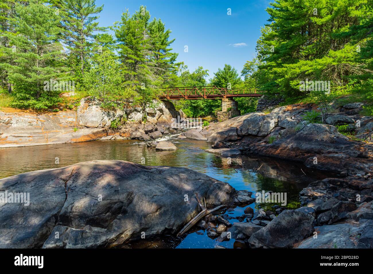 Victoria Falls Conservation Area  showing main bridge, two tone textured rocks and green forest on a sunny summer gorgeous day Stock Photo