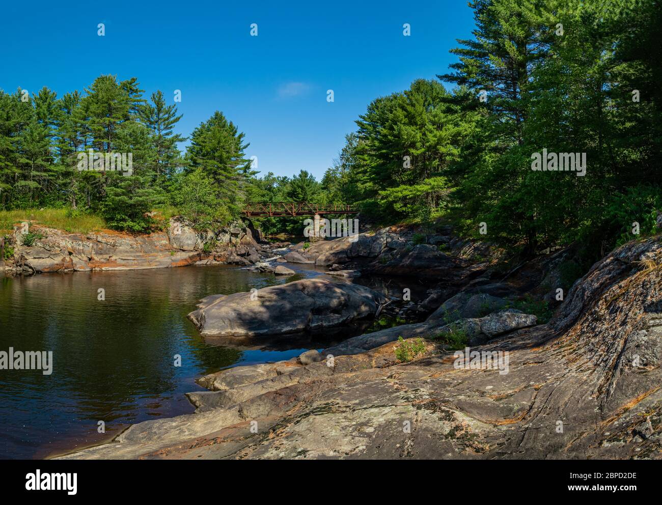 Victoria Falls Conservation Area  showing main bridge, two tone textured rocks and green forest on a sunny summer gorgeous day Stock Photo