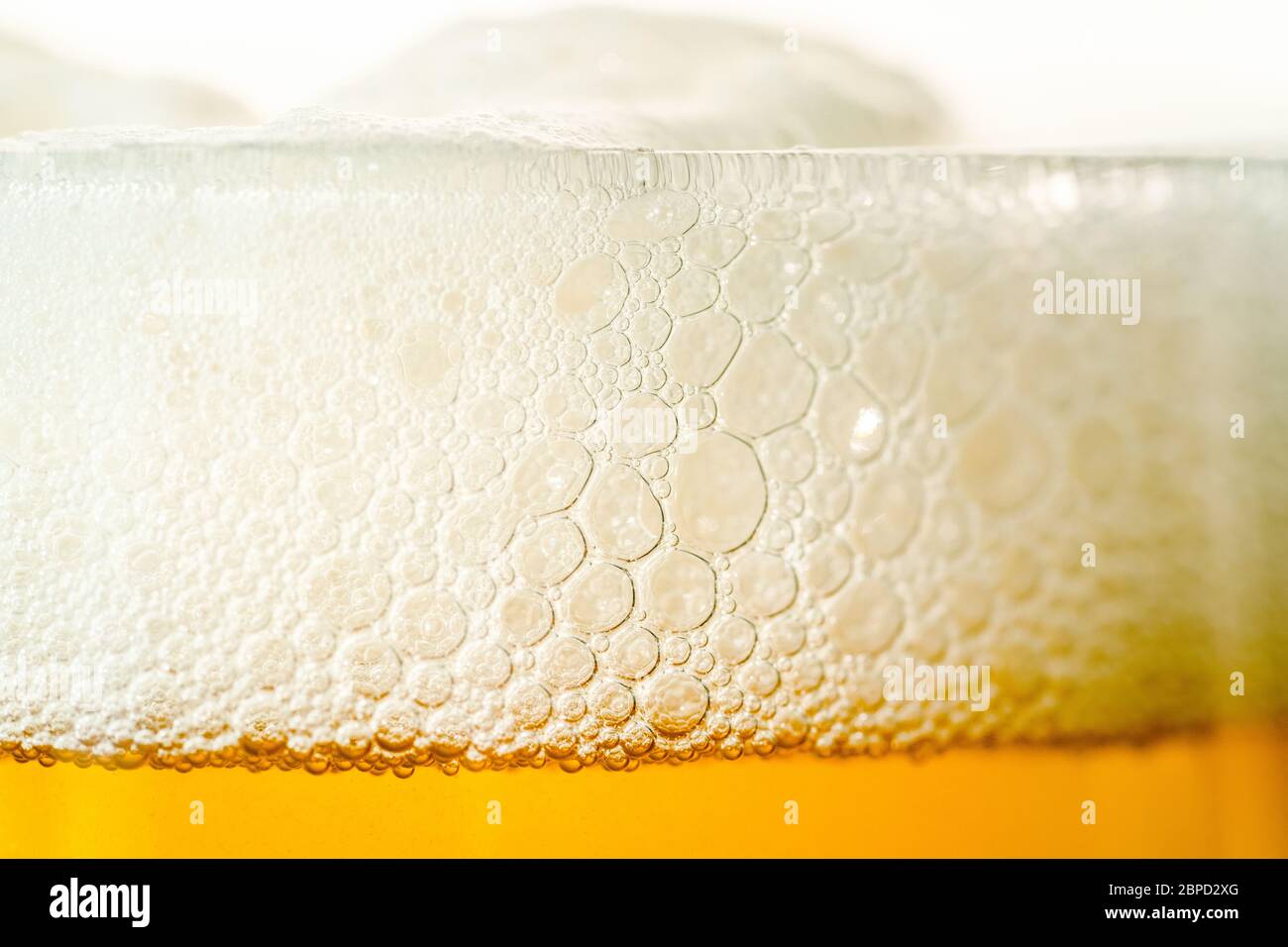 Craft beer glass with bubble froth close up, refreshing cold drink background. Stock Photo