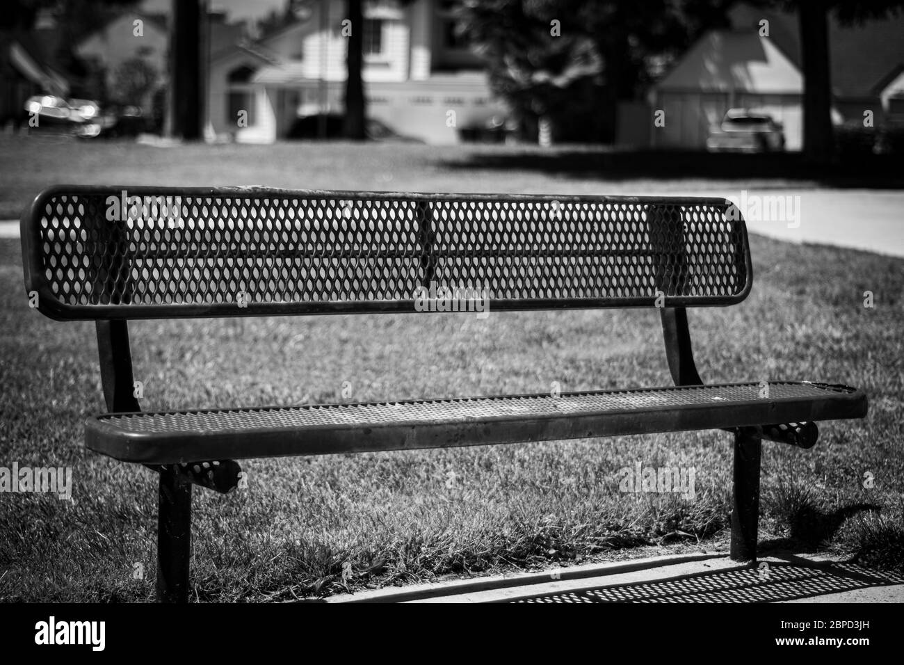 Empty park bench in deserted neighborhood park Stock Photo