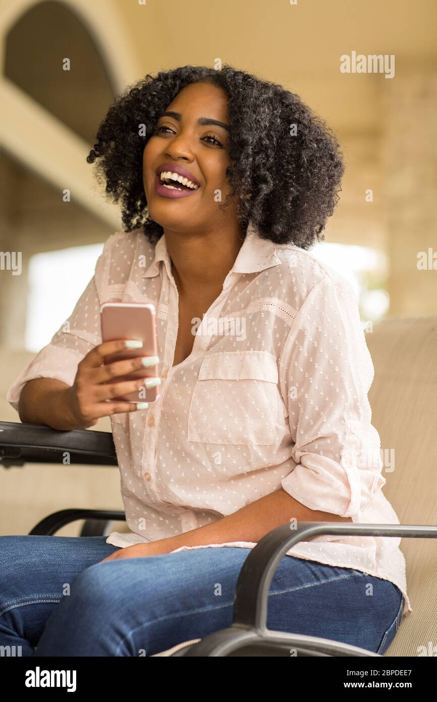 Happy African American woman texting and talking. Stock Photo