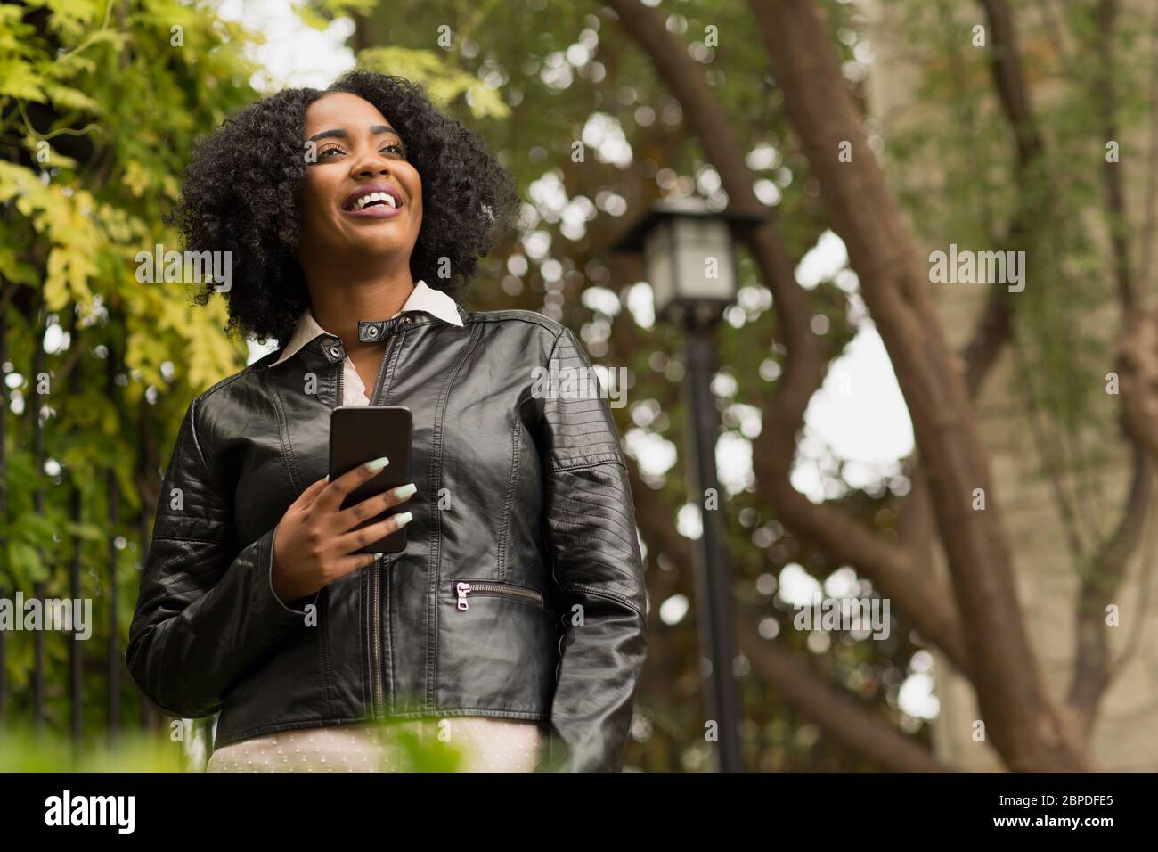 Confident African American Woman walking and texting. Stock Photo