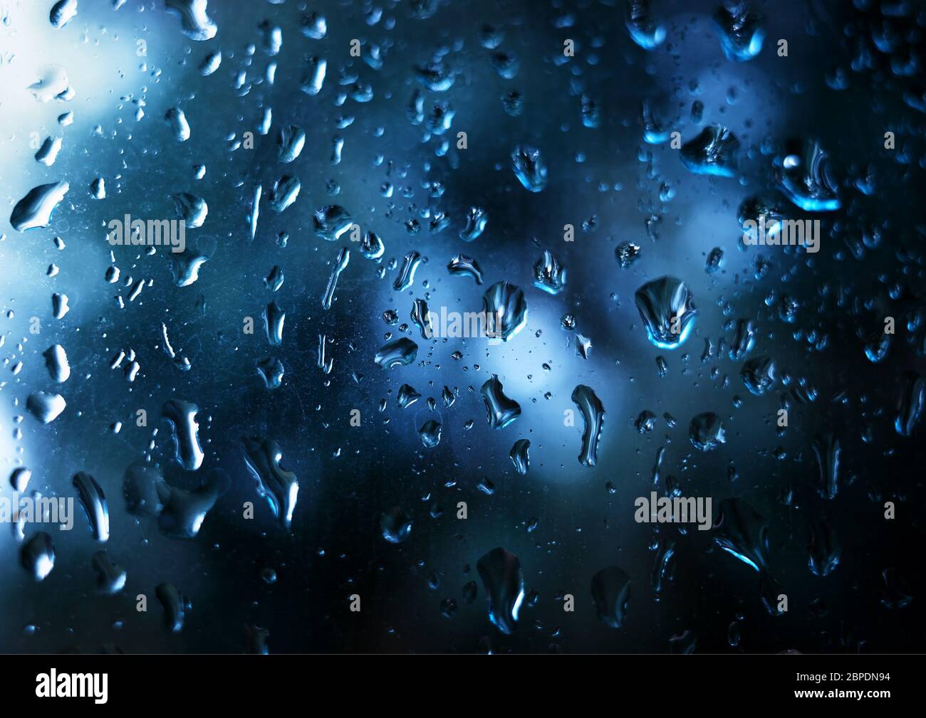 Vibrant raindrops on window glass background Stock Photo