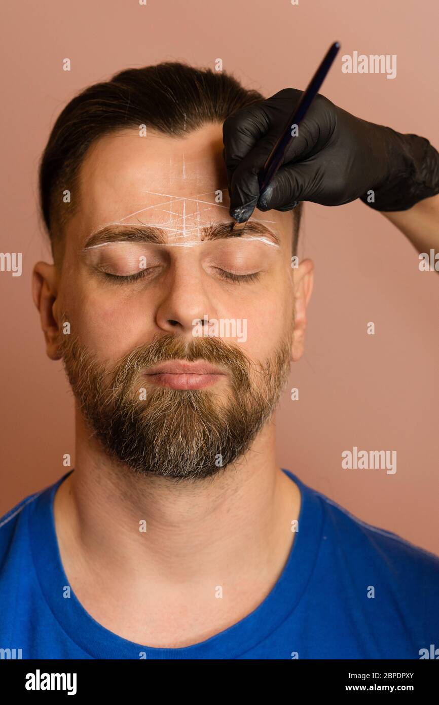 Permanent makeup for eyebrows. Tinting brows. Handsome man with