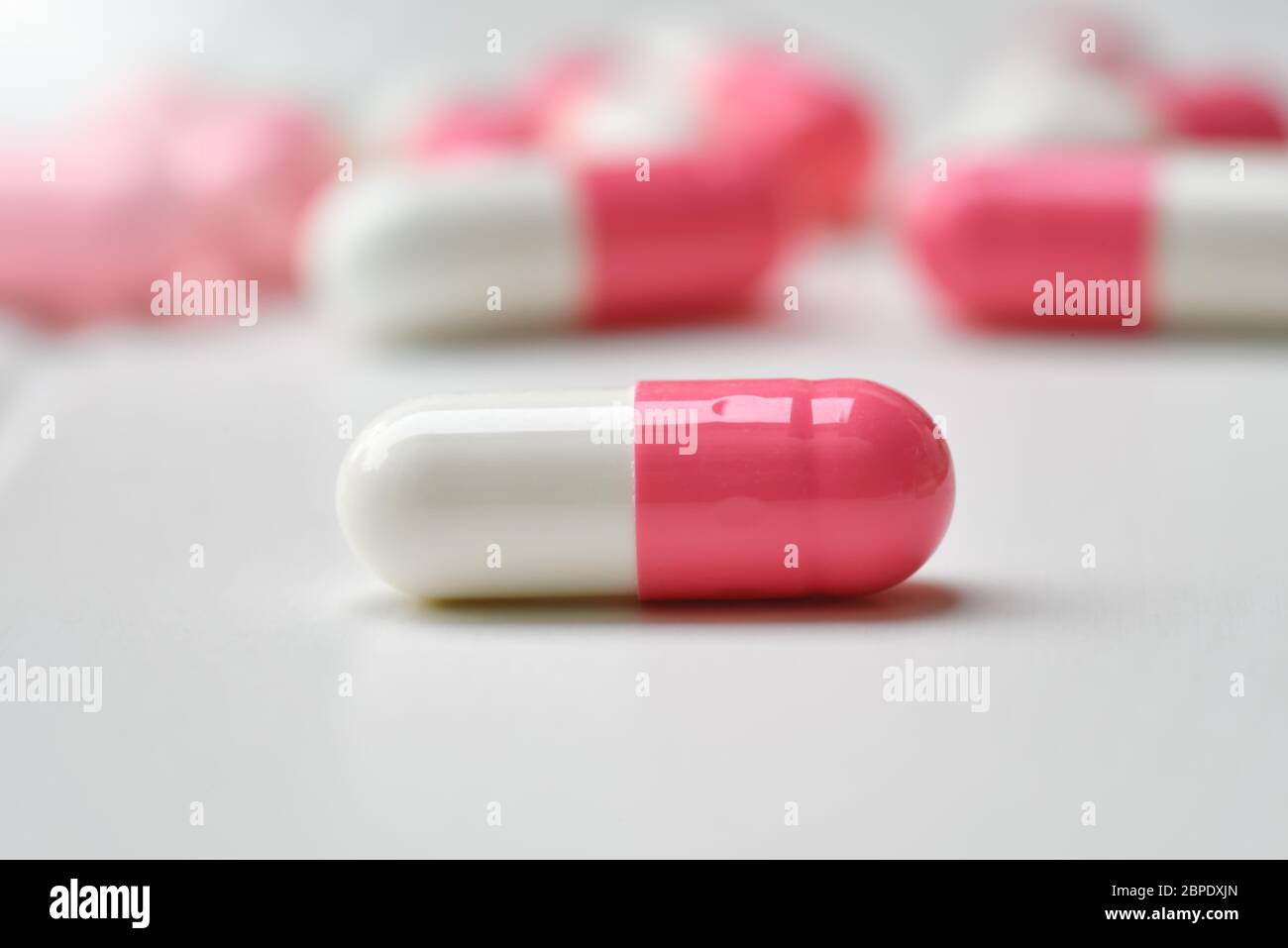 Pharmaceutical medicine pills, tablets and capsules pink-white on white background. Flat lay. Copy space. Medicine concepts. protect colona virus or c Stock Photo