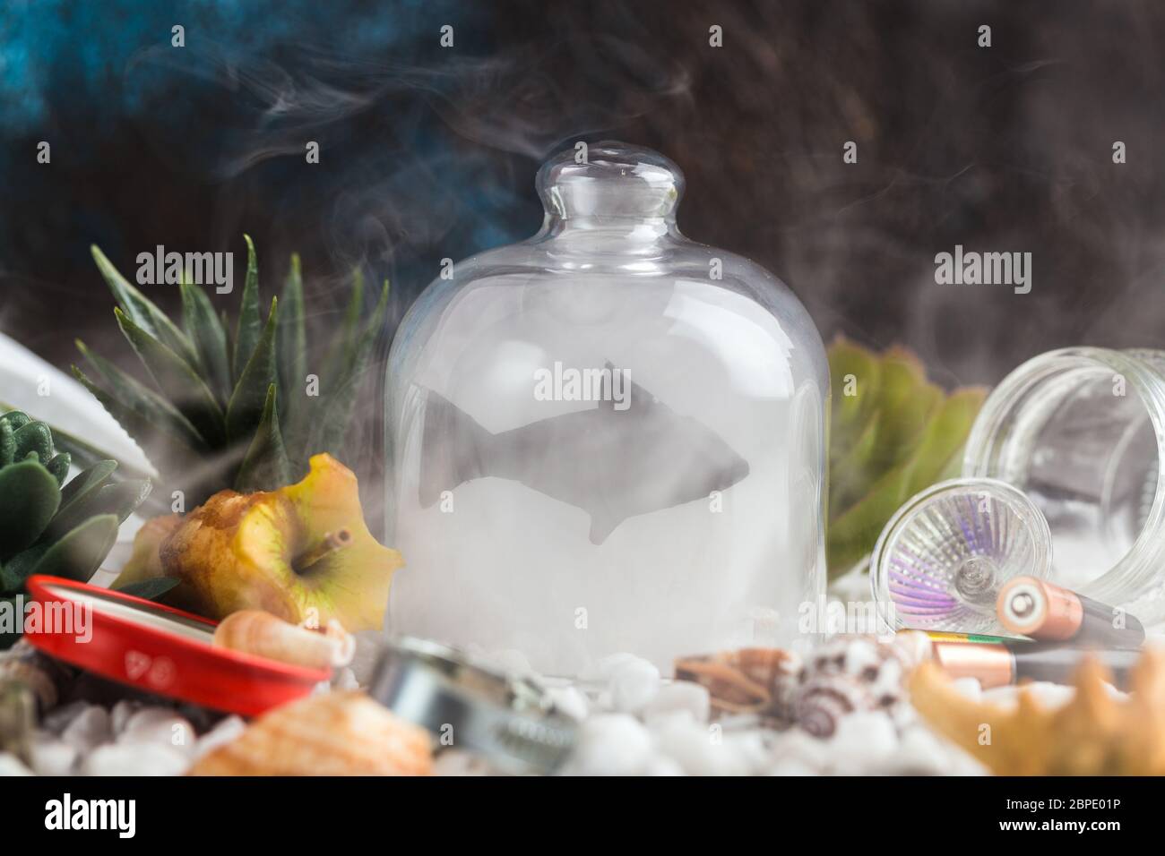 silhouette of fish under glass jar in polluted sea creative concept Stock Photo