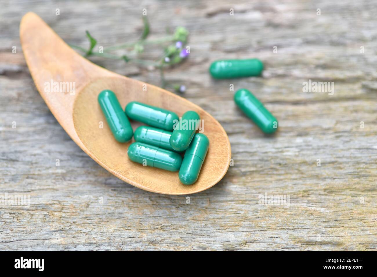 Herbal Medicines / Natural herb capsules Andrographis paniculata in spoon on wooden rustic background and copy space for using in medical background, Stock Photo