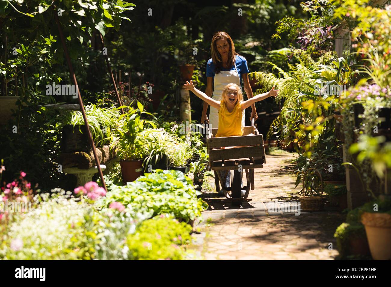 A Caucasian woman and her daughter sitting in a wheelbarrow Stock Photo ...