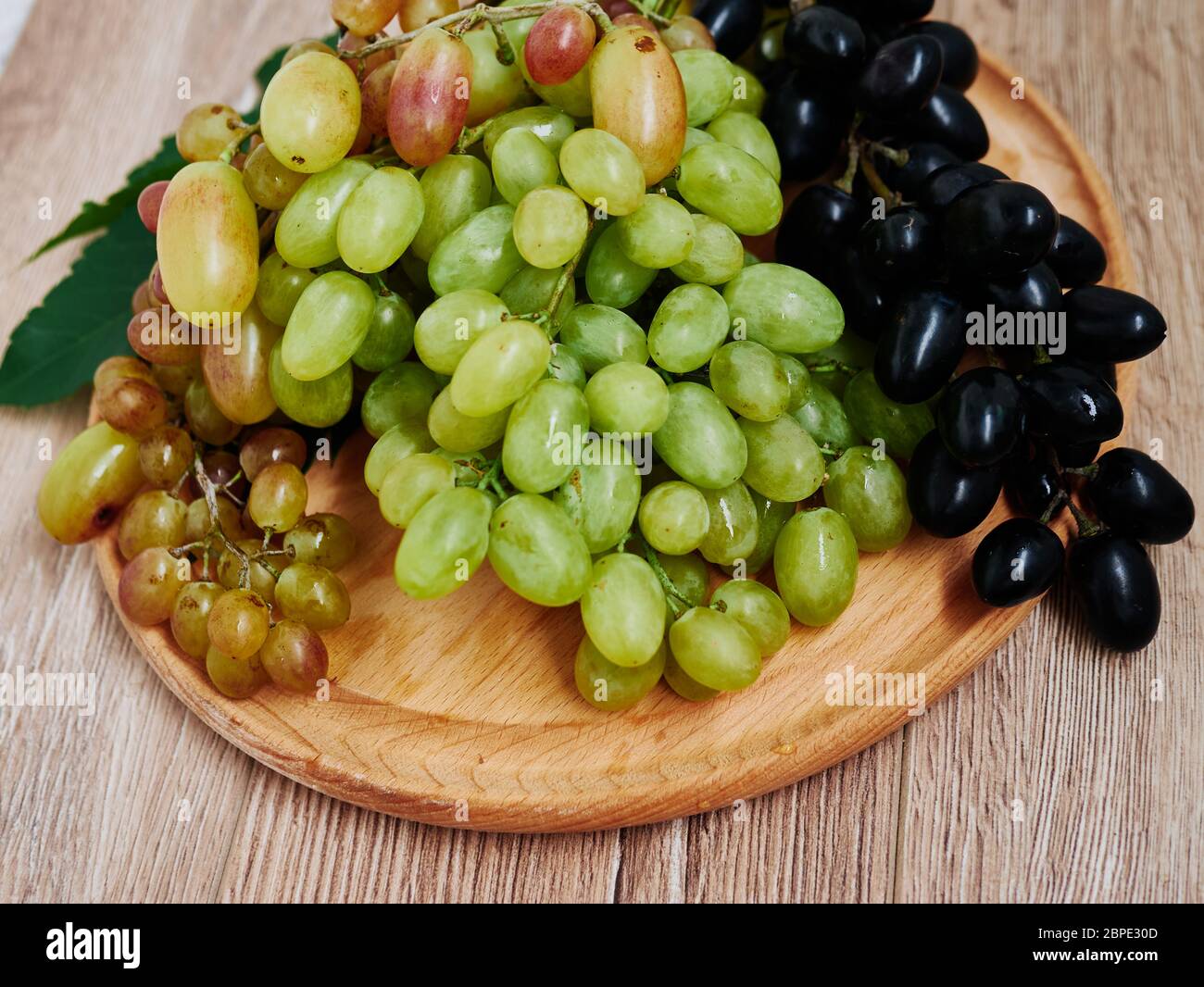 Healthy fruits. Red and green wine grapes on wooden background, dark and green organic wine grapes Stock Photo