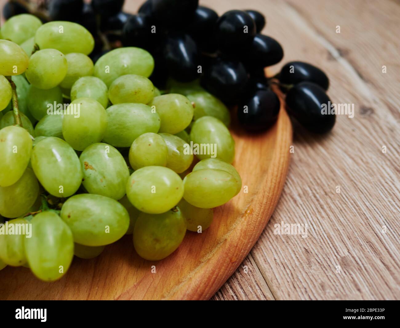 Healthy fruits. Red and green wine grapes on wooden background, dark and green organic wine grapes Stock Photo