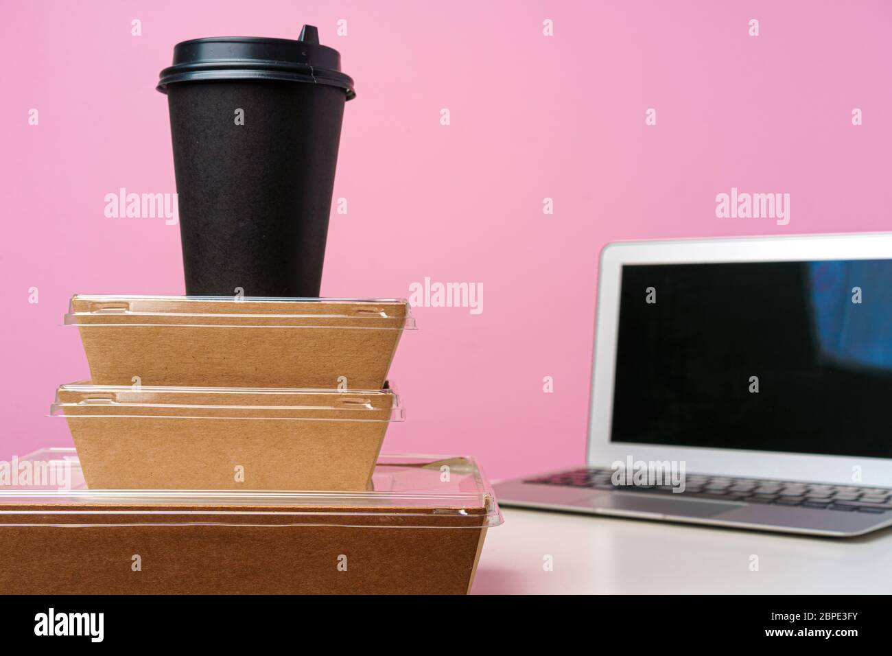 Eating in office. Home office. Food delivery package and open laptop Stock Photo Alamy