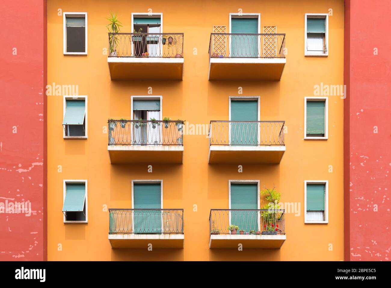 Bright colorful facade of old European building with windows, balconies and flowers in Verona, Italy. Laconic minimalist concept Stock Photo