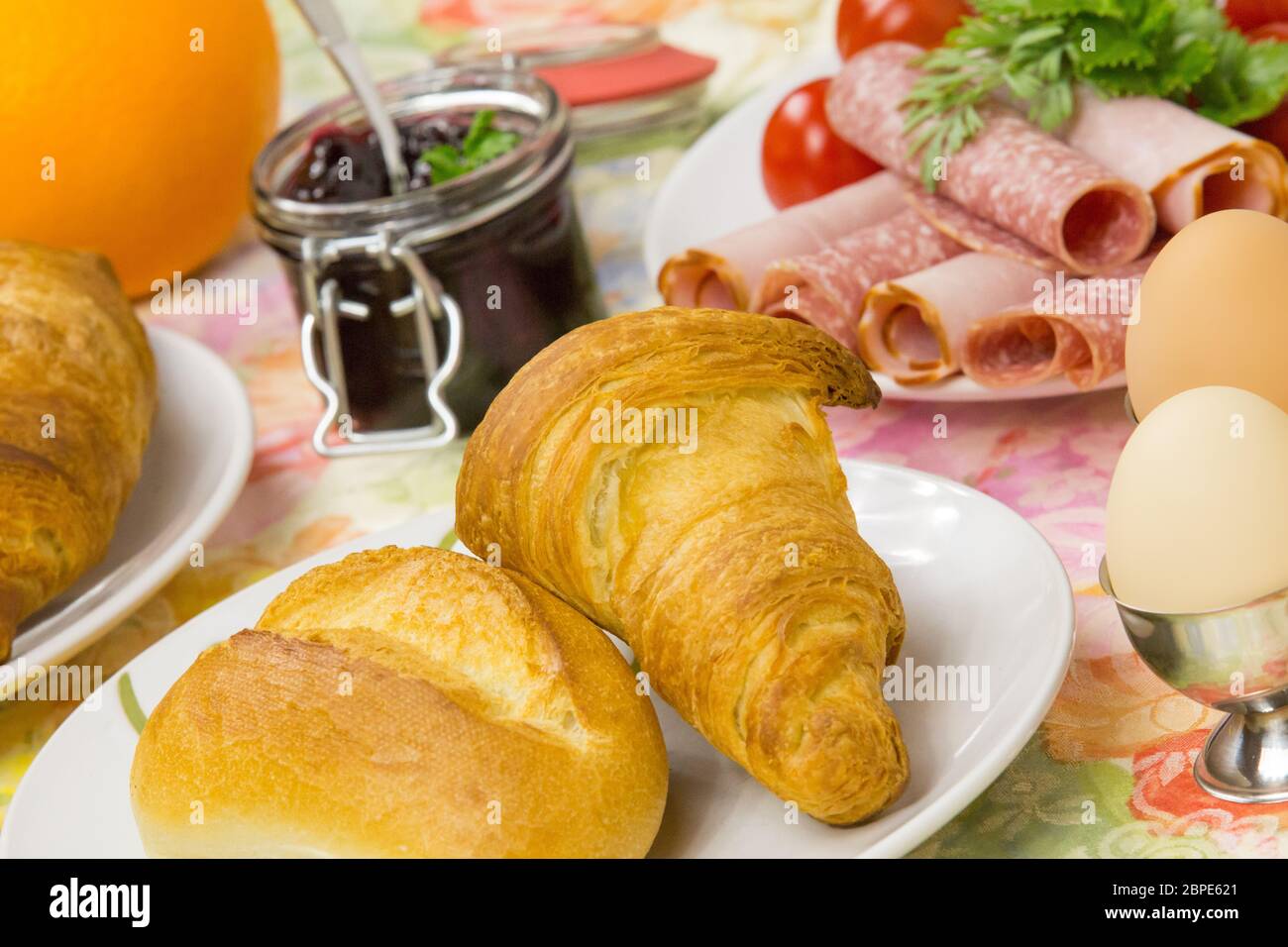 Frühstück mit Brötchen, Croissant, Ei und Aufschnitt Stock Photo