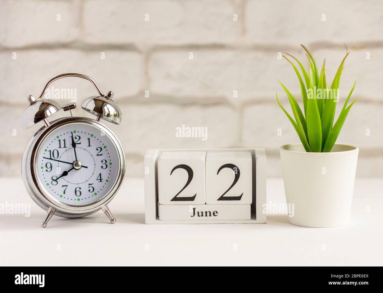 June 22 on a wooden calendar next to the alarm clock on the table. Summer day, empty space for text.Calendar date, birthday, or holiday Stock Photo - Alamy