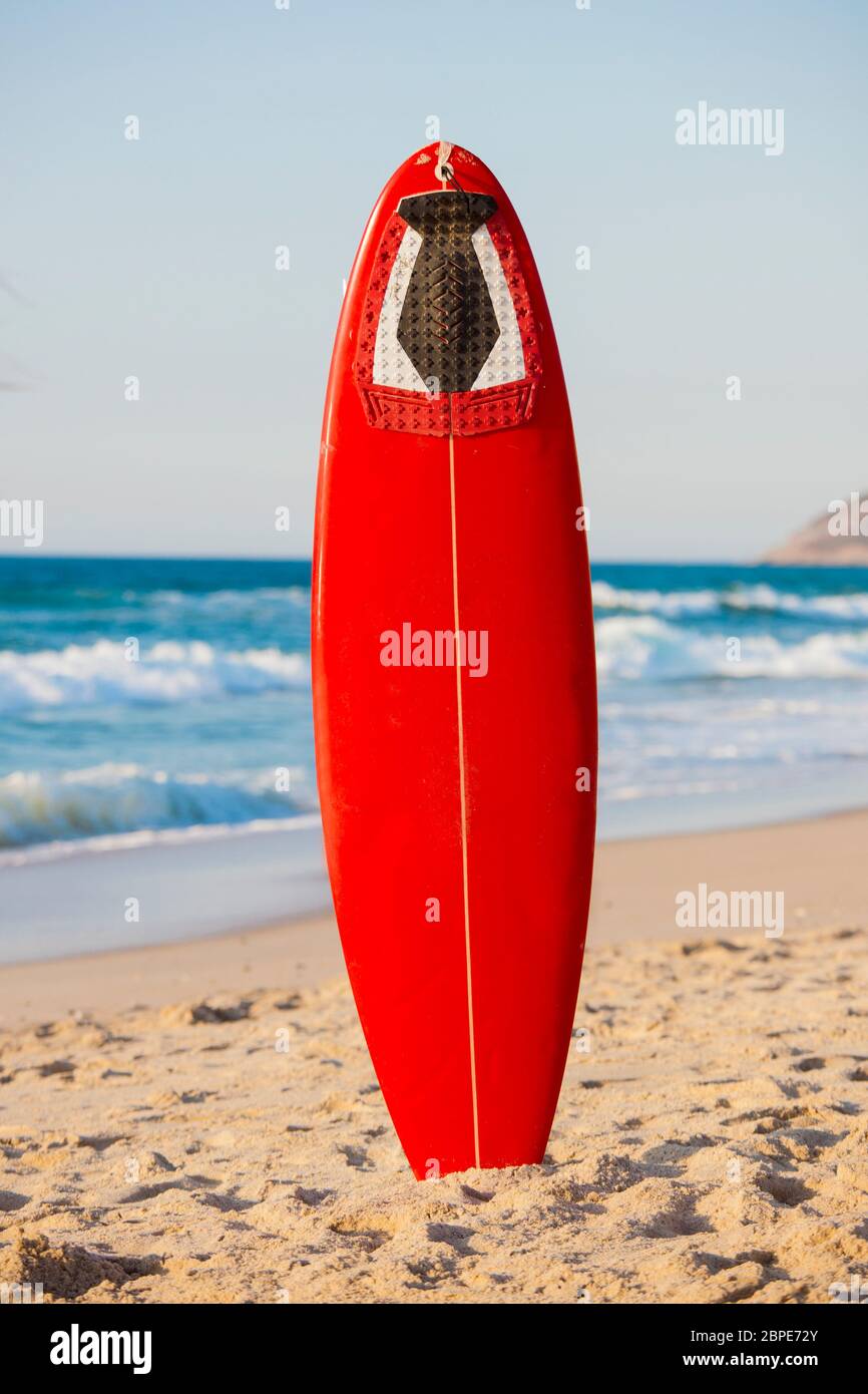 Red surfboard on the sand on a very beautiful sunny day Stock Photo - Alamy