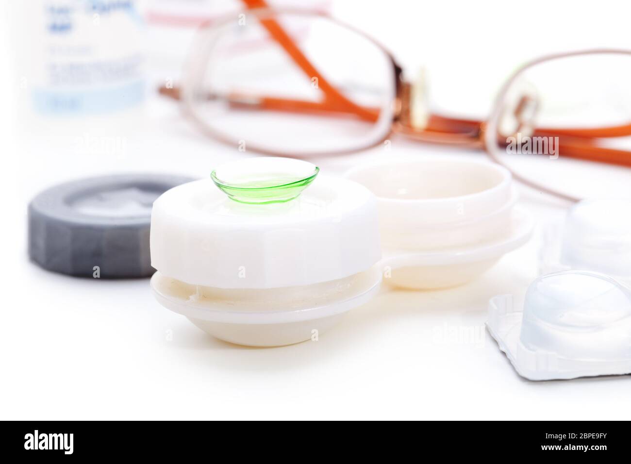 Close-up of green contact lenses in container with solution. Stock Photo