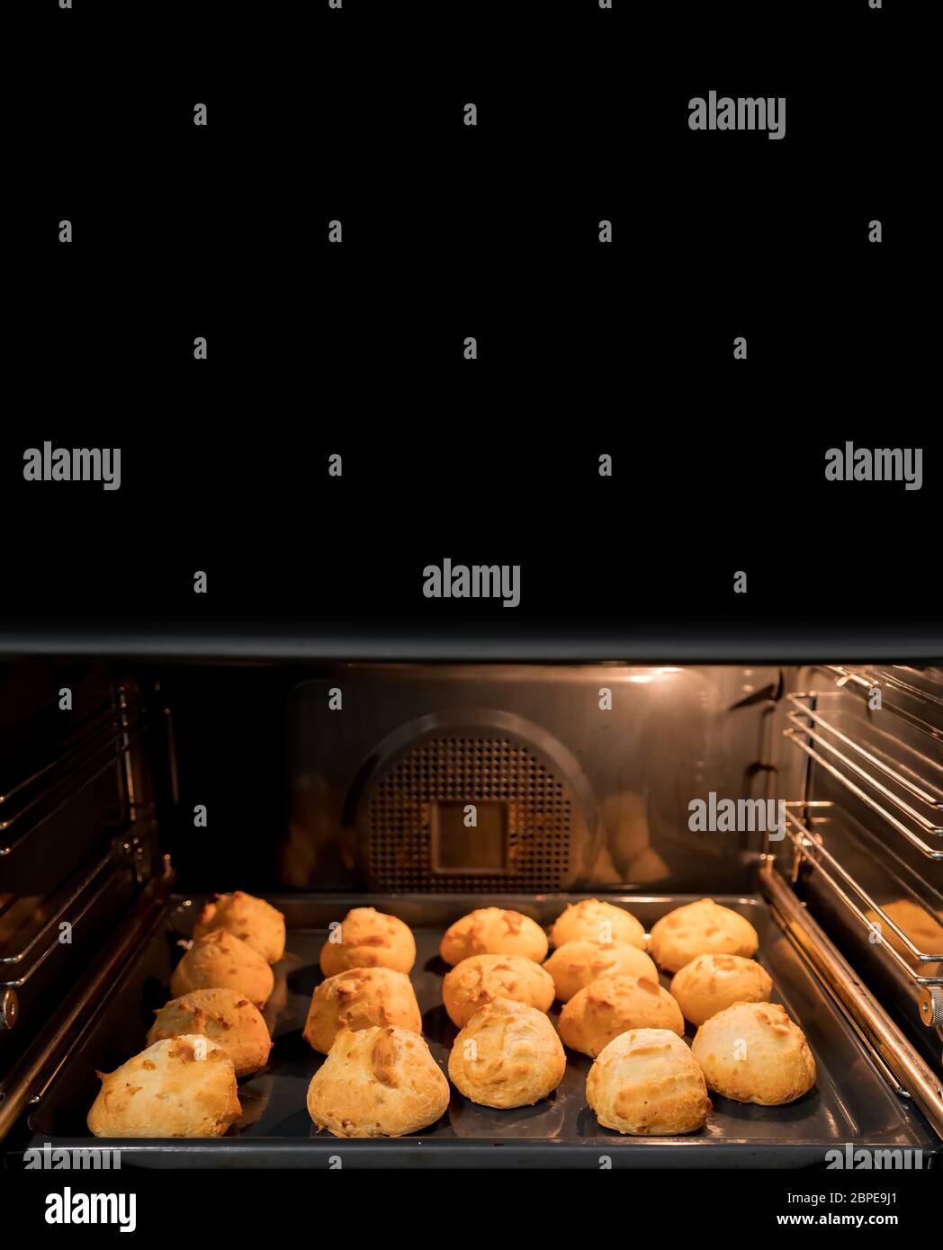 Preparing many cheese breads in home oven with text space Stock Photo