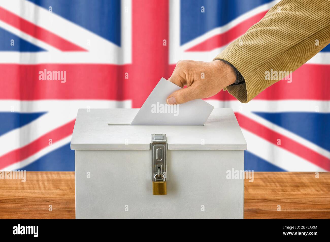 Mann wirft Stimmzettel in Wahlurne - Großbritannien Stock Photo