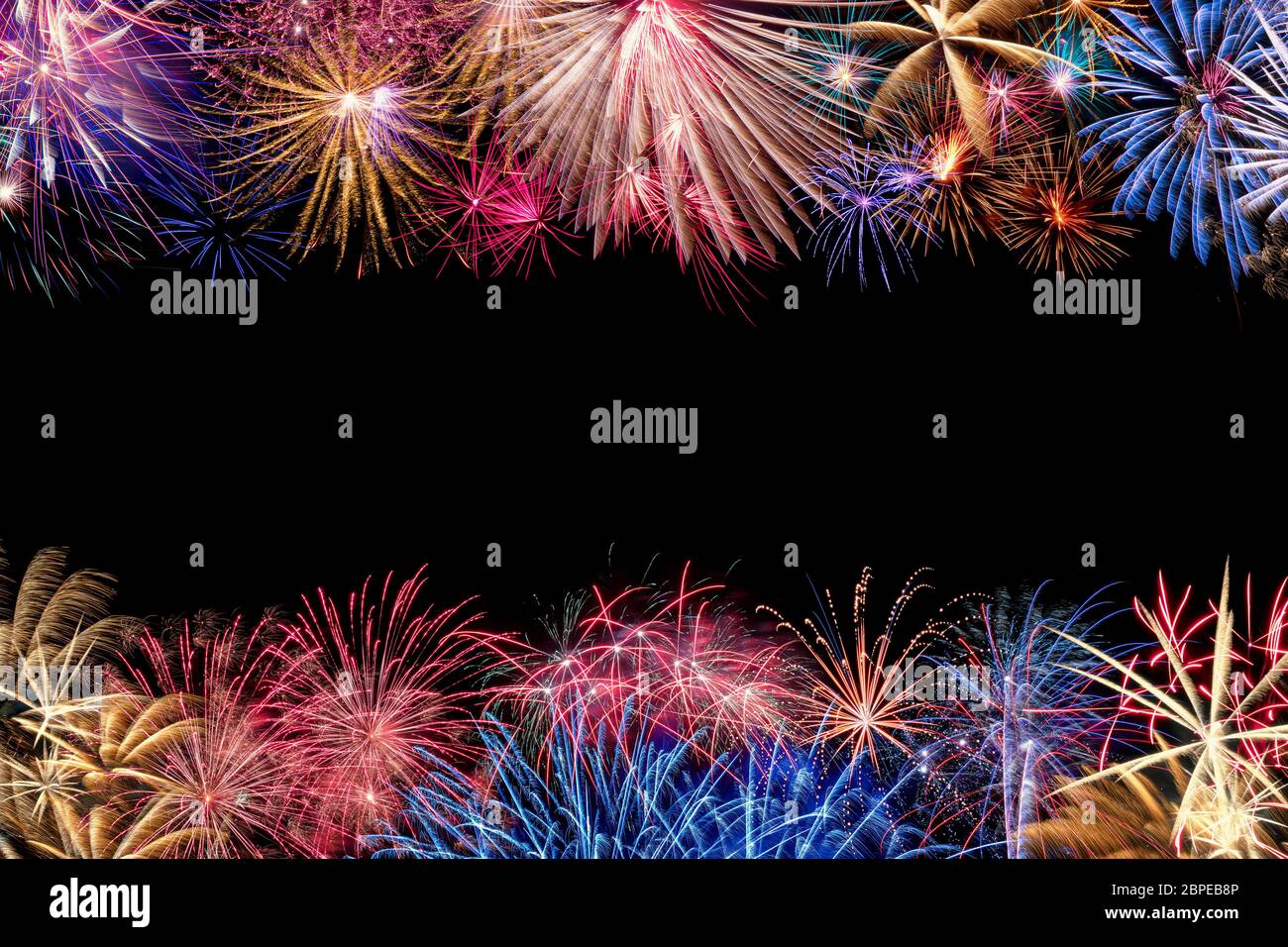 A very colorful border of different fireworks with copyspace in the middle of the image. Stock Photo