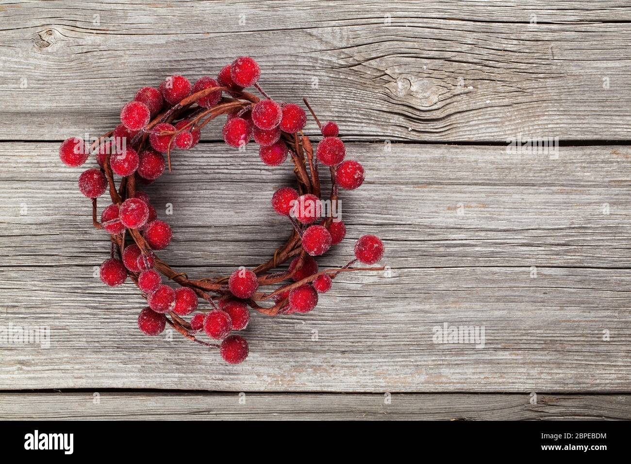 Adventskranz aus roten Beeren auf Holzuntergrund Stock Photo