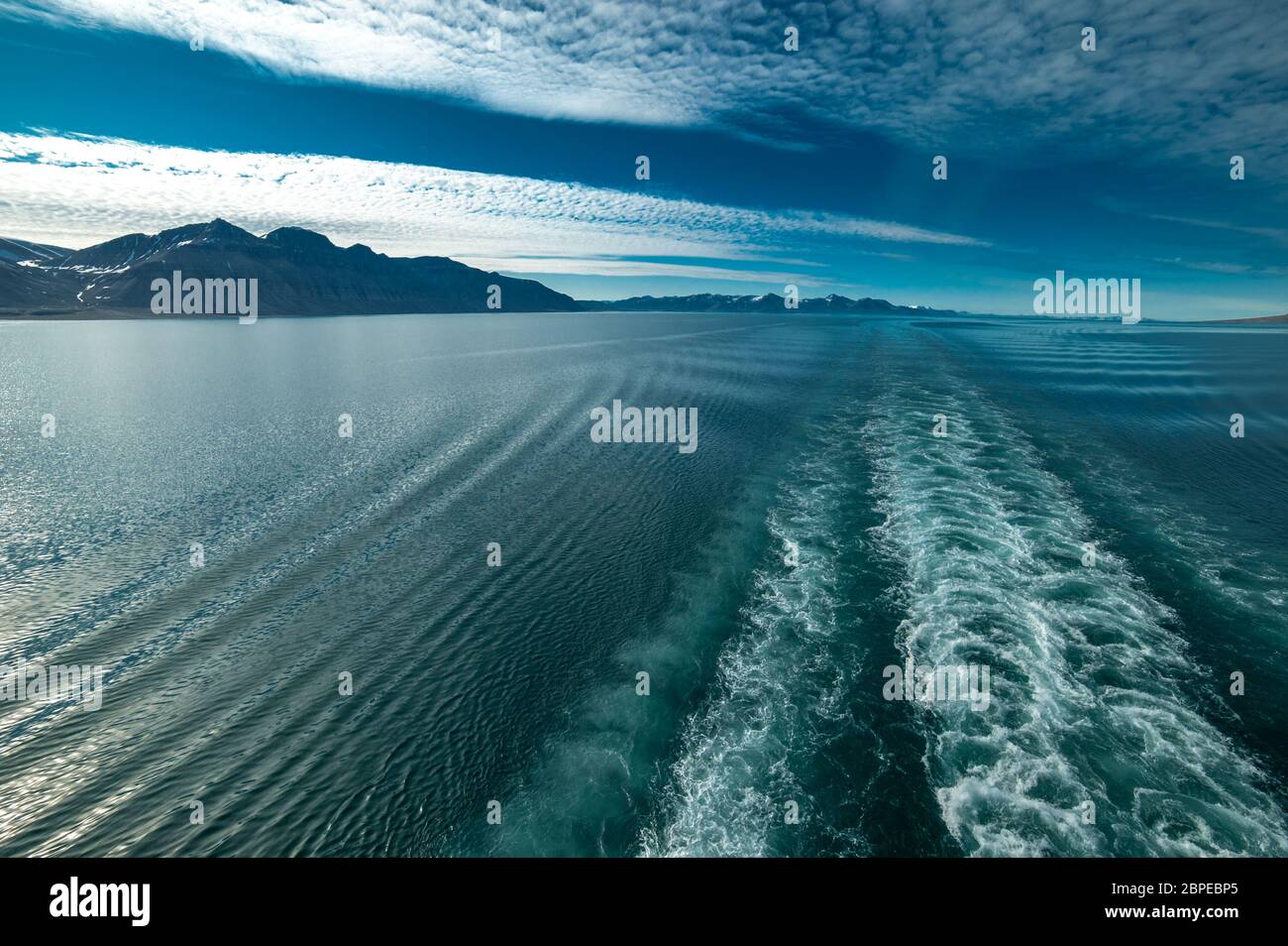 Abendstimmung an Bord eines Kreuzfahrtschiffs in den Fjorden Norwegens mit Spiegelung der Berge im Wasser Stock Photo