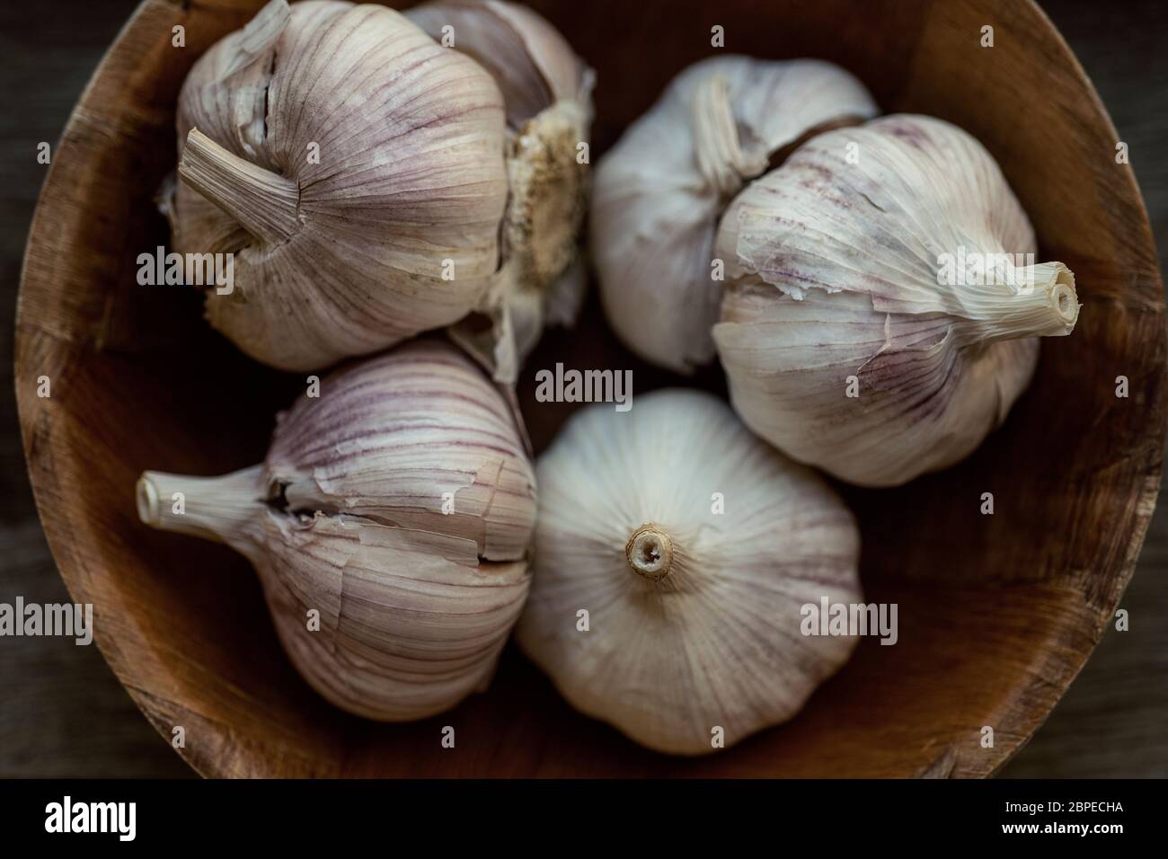 Few garlic bulbs and cloves over a wood table Stock Photo - Alamy