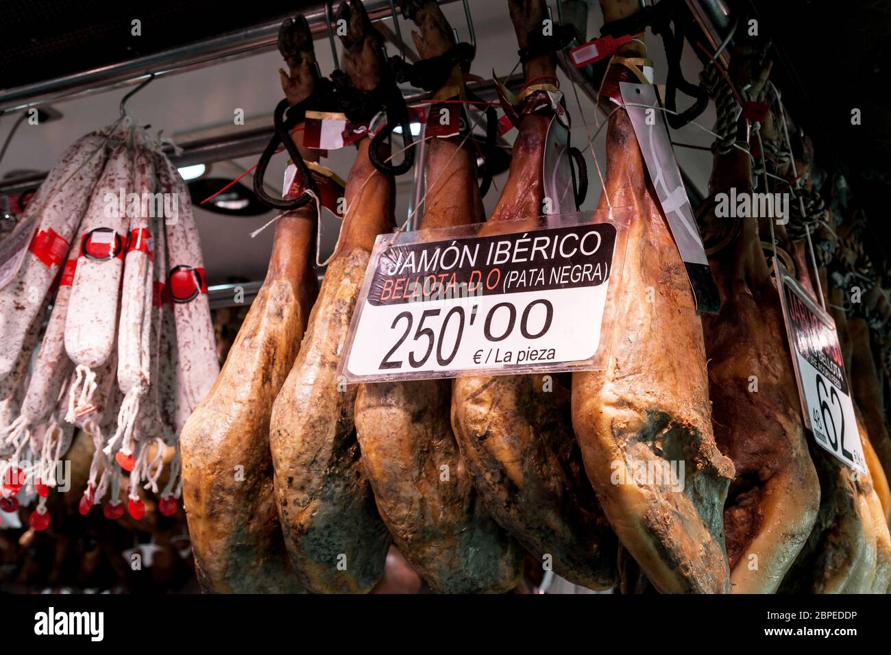 Nahaufnahme von großen iberischen  Schinken mit Preisschild auf einem spanischen Markt Stock Photo