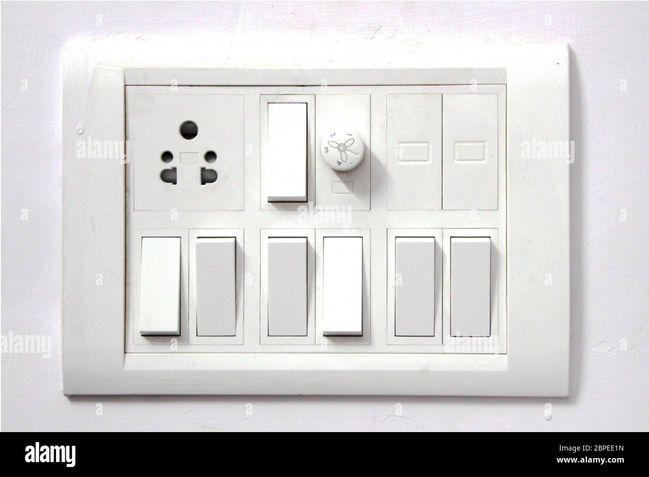 White electrical switch board panel on white concrete wall Stock Photo